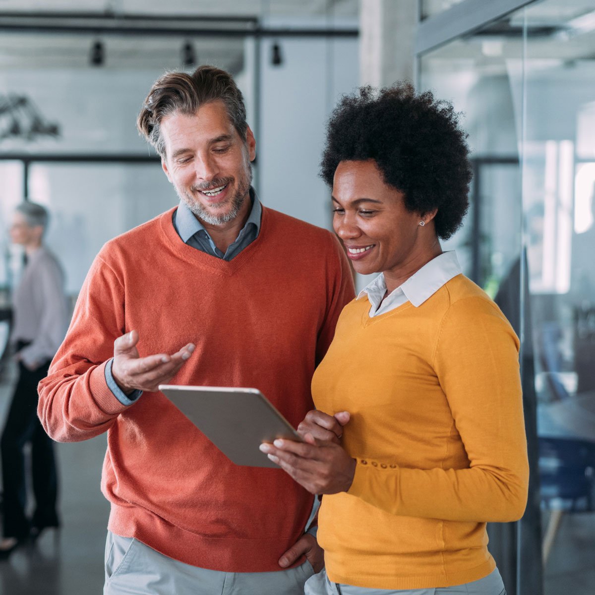 two business people in office on tablet