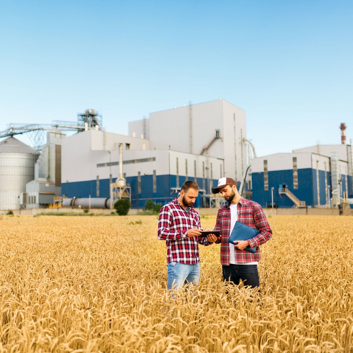 two farmers outside plant
