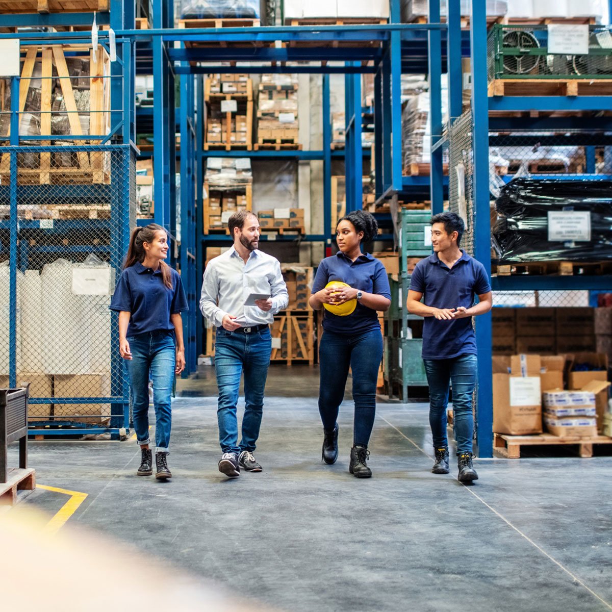 Warehouse Employees Walking Through Aisle